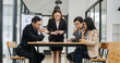 © Wicitr - Business team collaboration: A dynamic group of professionals engaged in a focused business discussion within a modern office setting, embodying teamwork and collaborative spirit.