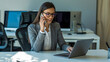 © MdAyub - A professional office scene with a woman in a gray business suit and white button-up shirt sitting at a white desk, engaged in a phone conversation