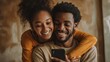 © Johannes - Smiling young couple embracing while looking at smartphone. Multiethnic couple sharing social media on smart phone. Smiling african girl embracing from behind her happy boyfriend while using cellphon
