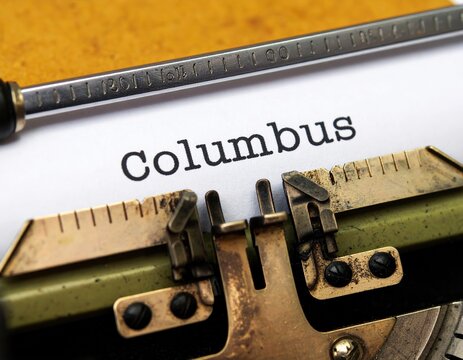 Close-up of vintage typewriter typing 'columbus' on paper