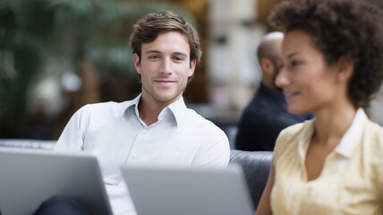 Aufkleber - Young man and woman working together on laptops, smiling, casual business environment, teamwork, collaboration