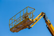 © K - yellow hydraulic boom lift aerial work platform under clear blue sky construction site machinery elevated access basket for maintenance industrial equipment high reach lift for building operations