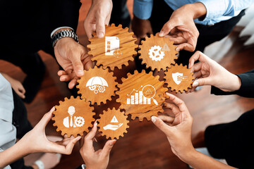 Poster - Hands gather around wooden gears, each symbolizing key business concepts. The image promotes teamwork, strategy, and collaboration in a modern corporate environment. Amity