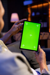 Poster - Relaxed male tech user holding device with isolated mockup screen in his living room, sitting on the couch and teleworking. African american happy guy browses the internet, outsourcing.