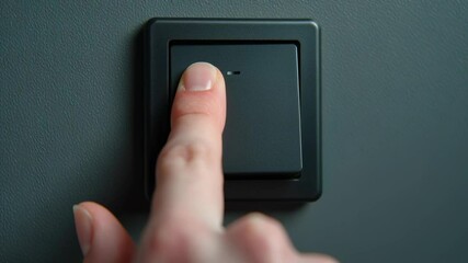 Aufkleber - close-up of a hand flipping off a modern led wall switch on a trendy interior surface