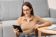 © Pixel-Shot - Young girl reading e-book at home