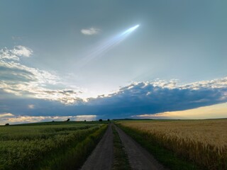 Wall Mural - glowing comet with a long tail in the sky at sunset. celestial body above the clouds, astronomical l