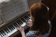 © Westend61 - Girl playing piano at home with sheet music