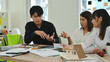 © saltdium - Professional design team having a focused discussion on construction plans and design solutions, surrounded by models and technical documents