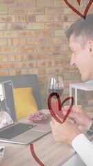 Poster - Heart icons over caucasian man holding a heart shaped placard while having a video call on laptop