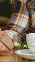 Poster - Globe of digital icons against mid section of man using smartphone and drinking coffee at a cafe