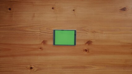 Poster - Green screen, hand and tablet with business person at wooden table for marketing from above. App, finger and mockup with employee in office for advertising, connectivity or social media selection
