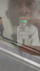 Poster - Animation of doctor with covid 19 vaccine over senior man wearing face mask