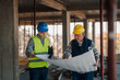 © Ljustina - Architect and construction worker discussing blueprint on building site