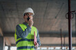 © Ljustina - Construction site supervisor communicating using walkie-talkie and holding clipboard