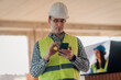 © Ljustina - Construction engineer using smartphone inside building under construction