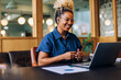 © (JLco) Julia Amaral - Smiling woman having a video call in a casual business setting