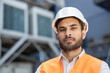 © Liubomir - A construction worker, wearing a hard hat and safety vest, looks directly at the camera with a serious expression.