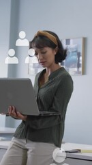 Poster - Animation of multiple profile icons floating against asian woman using laptop at office