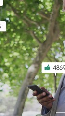 Poster - Animation of social media icons over african american man in face mask using smartphone
