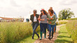 © Monkey Business - Group Of Smiling Mature Friends Walking Along Path Through Yurt Campsite