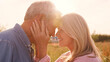 © Monkey Business - Close Up Of Loving Mature Couple In Countryside Hugging Head To Head Against Flaring Sun