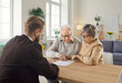 © Studio Romantic - Senior couple sitting at table and having consultation with financial agent about health insurance in retirement. Elderly man and woman studying terms of contract during visit of financial advisor.