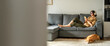 © Stock 4 You - Smiling young student woman lying on couch, listening music in headphones on mobile phone application. Relaxing girl at new real estate apartment home using mobile phone online app. Banner, copy space
