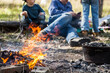 © Austockphoto - Campfire flames with boys relaxing around