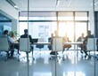 © rioyoungguns - Business professionals engaged in a meeting in a modern office with sunlight streaming through large windows