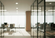 © birulaut - Blurred office interior with glass walls desks and chairs in a bright space.