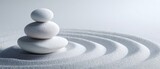 The tranquil arrangement of white stones on a layer of sand.