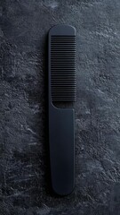 Poster - A simple still life image of a black comb sitting on a black table