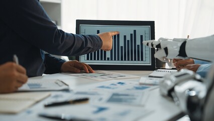 Poster - Professionals engage in a dynamic business meeting analyzing data charts while utilizing advanced technology to enhance productivity and decision-making.Noogenesis