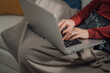 © Zamrznuti tonovi - Woman working from home using laptop on sofa covered with blanket