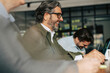 © Maskot - Happy senior businessman with colleagues in meeting at office