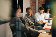 © Maskot - Group of diverse business professionals in meeting at office