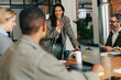 © Maskot - Smiling businesswoman interacting with colleagues in meeting at office