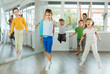 © JackF - Group of positive juvenile boys and girls jumping cheerfully in dancehall during workout session