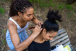 © tessy morelli/Stocksy - Friends braiding Hair in a Park During a Sunny Afternoon