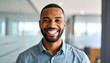 © cinta - Happy young man with confident smile in modern workplace setting