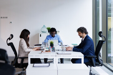 Group of IT specialists working side by side at open space office