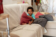 © Anna Fedorova/Stocksy - Happy toddler boy holding a pillow, sitting on a sofa