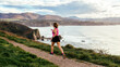 © Marco Govel/Stocksy - Woman running by coastline trail