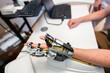 © Alvaro Lavin/Stocksy - Patient testing futuristic robotic hand prosthesis in medical facility