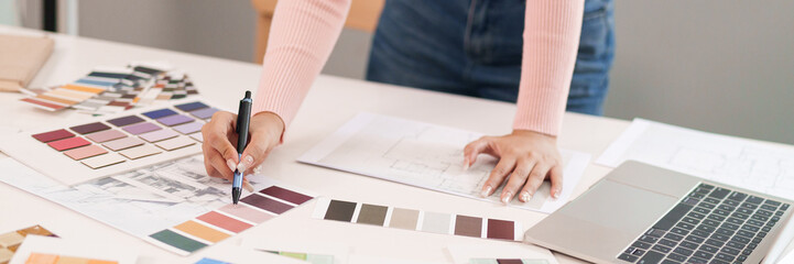 Wall Mural - Asian Women UI Designer Choosing Color Palette for Website Design Inspiration and Laptop on Table for Design Process Asian Interior Designer Work