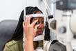 © Alvaro Lavin/Stocksy - Optician examining patient eyesight with phoropter during eye exam