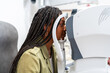 © Alvaro Lavin/Stocksy - Patient using a phoropter for eye exam during a visit