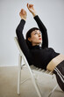© Javier Díez/Stocksy - Model relaxes in a stylish chair during a fashion shoot indoors