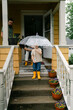 © Lea Jones/Stocksy - little boy getting down front door steps in the rain
